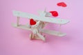 Happy Valentines day. wooden children`s plane on a pink background with red heart, and garland in the shape of a heart Royalty Free Stock Photo