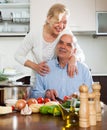 Happy vegetarian woman smiling with senior and cooking
