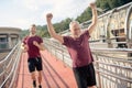 Mature grey-haired male raising both hands, winning running race