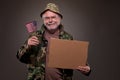 Happy Vietnam Veteran holding a cardboard piece and American fla