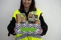 Happy volunteer holding a basket with donated food Royalty Free Stock Photo