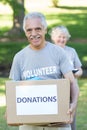 Happy volunteer senior holding donation box