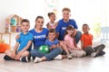 Happy volunteers with children sitting on floor