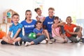 Happy volunteers with children sitting on floor