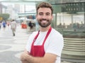 Happy waiter with beard in front of a restaurant