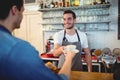 Happy waiter giving coffee to customer at cafe Royalty Free Stock Photo