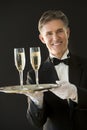 Happy Waiter Holding Serving Tray With Champagne Flutes Royalty Free Stock Photo