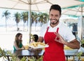 Happy waiter serving french fries at beach bar Royalty Free Stock Photo