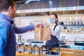 Happy waitress wearing protective face mask serving takeaway food to customer at counter in small family restaurant Royalty Free Stock Photo