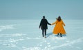 Happy walking couple. In love man and woman walking on the snowy ice. Winter vacation concept. Royalty Free Stock Photo