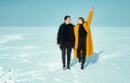 Happy walking couple. In love man and woman walking on the snowy ice. Winter vacation concept. Royalty Free Stock Photo