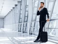 Happy wealthy businessman standing in airport, talking on mobile phone Royalty Free Stock Photo