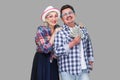 Happy wealthy family, adult man and woman in casual checkered shirt standing pickaback together, holding fan of dollar, toothy