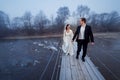 Happy wedding couple laughing and having fun on the suspension bridge in mountains Royalty Free Stock Photo