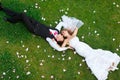 Happy wedding couple lying on green grass Royalty Free Stock Photo