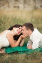 Happy wedding couple lying on green grass at the summer time Royalty Free Stock Photo