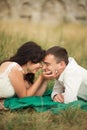 Happy wedding couple lying on green grass at the summer time Royalty Free Stock Photo