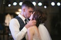 Happy wedding couple performs the first dance in a restaurant, hug and kiss Royalty Free Stock Photo