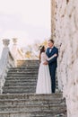 Happy wedding couple stand on antique stone stairs. Full length portrait Royalty Free Stock Photo