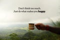 Happy Weekend inspirational quote - Don`t think too much. Just do what make you happy. Hand of person holding a cup of coffee. Royalty Free Stock Photo