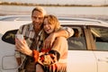 Happy white couple taking selfie photo by car while walking at seashore Royalty Free Stock Photo