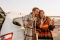 Happy white couple taking selfie photo by car while walking at seashore Royalty Free Stock Photo