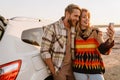 Happy white couple taking selfie photo by car while walking at seashore Royalty Free Stock Photo