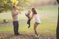 Happy white family spending time in the park - father blowing soap bubbles and his wife and son smiling Royalty Free Stock Photo