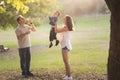 Happy white family spending time in the park - little boy held by his mother catching the soap bubbles his father Royalty Free Stock Photo