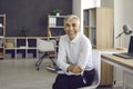 Portrait of happy mature businessman sitting on chair, smiling and looking at camera Royalty Free Stock Photo