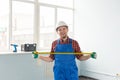 Happy white male builder infront of window with tape measure Royalty Free Stock Photo