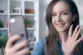 Happy white woman using phone, having video call, video chatting at home. Royalty Free Stock Photo