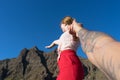 Happy wife holding the hand of his husband and pointing to the mountain, standing and pulling. Royalty Free Stock Photo