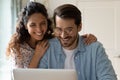 Happy wife and husband looking at laptop screen