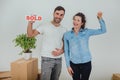 Happy wife and husband standing together. Woman is holding keys to their apartment. Man is looking at the camera Royalty Free Stock Photo