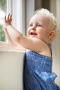 Happy, window and baby with smile standing against glass or wall in family home learning to walk. Girl, female toddler Royalty Free Stock Photo