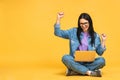 Happy winner! Business concept. Portrait of happy young woman in casual sitting on floor in lotus pose and holding laptop isolated Royalty Free Stock Photo