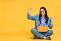 Happy winner! Business concept. Portrait of happy young woman in casual sitting on floor in lotus pose and holding laptop isolated Royalty Free Stock Photo