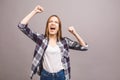 Happy winner! Close-up of emotional young attractive woman with keeping hands in fists, isolated on grey background. Surprised Royalty Free Stock Photo
