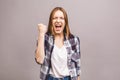 Happy winner! Close-up of emotional young attractive woman with keeping hands in fists, isolated on grey background. Surprised Royalty Free Stock Photo