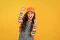 Happy winner. Happy little girl making winning gesture on yellow background. Cheerful small child happy smiling with