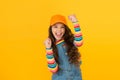 Happy winner. Happy little girl making winning gesture on yellow background. Cheerful small child happy smiling with