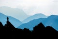 One Man reaching summit after climbing and hiking enjoying freedom and looking towards mountains silhouettes panorama Royalty Free Stock Photo