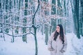 Happy Winter Girl. Portrait of a young woman in snow trying to warm herself. Beautiful girl in the winter forest in Royalty Free Stock Photo