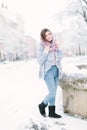 Happy winter time in big city of charming girl walking on street in warm knitted sweater. Enjoying snowfall, expressing Royalty Free Stock Photo
