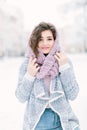 Happy winter time in big city of charming girl walking on street in warm sweater. Enjoying snowfall, expressing Royalty Free Stock Photo