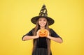 happy witch child with pumpkin jack o lantern wear costume of wizard on halloween party, halloween tradition Royalty Free Stock Photo