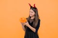 happy witch devil kid wear imp horns costume on halloween party and hold pumpkin jack o lantern, happy halloween Royalty Free Stock Photo