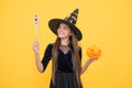 Happy witch kid with magic wand and pumpkin jack o lantern wear costume of wizard on halloween party, halloween miracle Royalty Free Stock Photo