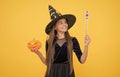 happy witch kid with magic wand and pumpkin jack o lantern wear costume of wizard on halloween party, halloween miracle Royalty Free Stock Photo